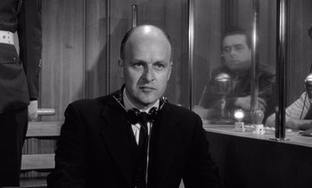 Movie still from “Judgment at Nuremberg” (1961), directed by Stanley Kramer – A black and white photo of a man in a suit and tie; Medium shot, Low angle