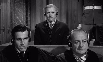 Movie still from “Judgment at Nuremberg” (1961), directed by Stanley Kramer – A man in a courtroom with two other men; Medium shot, Low angle