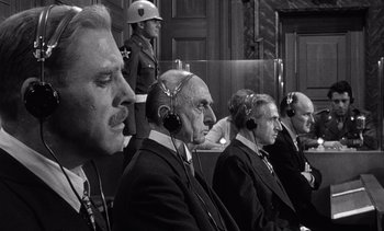 Movie still from “Judgment at Nuremberg” (1961), directed by Stanley Kramer – A black and white photo of a group of men sitting in a courtroom; Medium shot, High angle