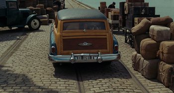 Movie still from “Julie & Julia” (2009), directed by Nora Ephron – An old car is parked on the side of the road; Wide shot, High angle