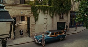 Movie still from “Julie & Julia” (2009), directed by Nora Ephron – An old car parked on the side of the street; Extreme Wide shot, High angle