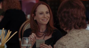 Movie still from “Julie & Julia” (2009), directed by Nora Ephron – A woman sitting in front of a glass of wine; Close Up shot, Over the shoulder angle