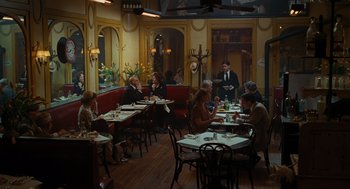 Movie still from “Julie & Julia” (2009), directed by Nora Ephron – A group of people sitting at tables in a restaurant; Wide shot, High angle