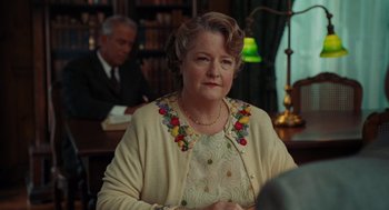 Movie still from “Julie & Julia” (2009), directed by Nora Ephron – An older woman wearing a dress and a sweater; Medium shot, Over the shoulder angle