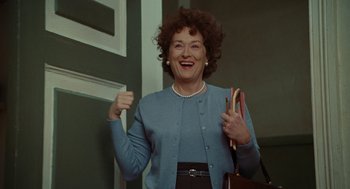 Movie still from “Julie & Julia” (2009), directed by Nora Ephron – An older woman is smiling while holding a bunch of colored pencils; Medium shot, Low angle
