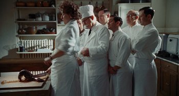 Movie still from “Julie & Julia” (2009), directed by Nora Ephron – A group of people standing in a kitchen; Medium shot, High angle