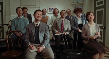 Movie still from “Julie & Julia” (2009), directed by Nora Ephron – A group of people sitting in a room; Medium shot, Over the shoulder angle