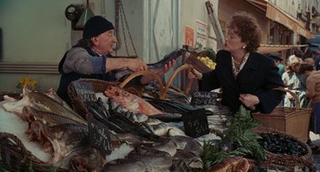 Movie still from “Julie & Julia” (2009), directed by Nora Ephron – A man and a woman sitting at a fish market; Medium shot, High angle