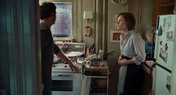 Movie still from “Julie & Julia” (2009), directed by Nora Ephron – A man and a woman standing in front of an oven; Medium shot, Over the shoulder angle