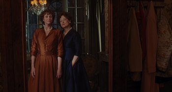 Movie still from “Julie & Julia” (2009), directed by Nora Ephron – Two women standing next to each other in front of a mirror; Medium shot, Low angle