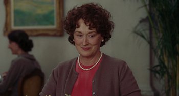 Movie still from “Julie & Julia” (2009), directed by Nora Ephron – An older woman wearing a red shirt and a necklace; Close Up shot, Over the shoulder angle