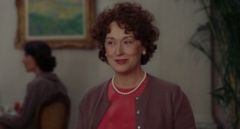 Movie still from “Julie & Julia” (2009), directed by Nora Ephron – An older woman wearing a red shirt and a pearl necklace; Close Up shot, Over the shoulder angle