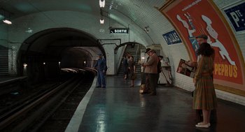 Movie still from “Julie & Julia” (2009), directed by Nora Ephron – A group of people standing on a platform near a train station; Extreme Wide shot, High angle