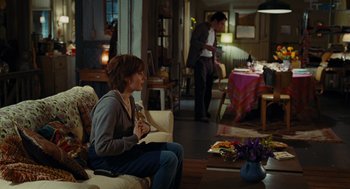 Movie still from “Julie & Julia” (2009), directed by Nora Ephron – A woman sitting on a chair in a living room; Wide shot, Over the shoulder angle