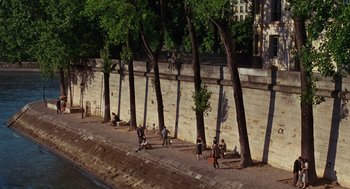 Movie still from “Julie & Julia” (2009), directed by Nora Ephron – A group of people sitting on the side of a river; Extreme Wide shot, High angle
