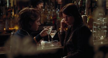 Movie still from “Julie & Julia” (2009), directed by Nora Ephron – Two women sitting at a table with a drink; Medium shot, Over the shoulder angle