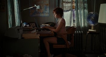 Movie still from “Julie & Julia” (2009), directed by Nora Ephron – A woman sitting at a desk using a computer; Wide shot, High angle