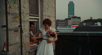 Movie still from “Julie & Julia” (2009), directed by Nora Ephron – A woman in a white dress holding a bouquet of flowers; Wide shot, Over the shoulder angle