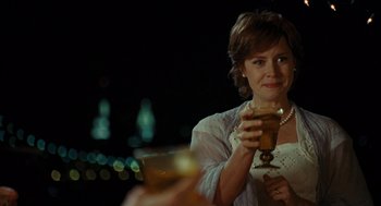 Movie still from “Julie & Julia” (2009), directed by Nora Ephron – A woman holding a wine glass and looking at the camera; Close Up shot, Over the shoulder angle