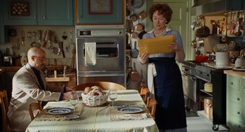 Movie still from “Julie & Julia” (2009), directed by Nora Ephron – A woman standing in front of a table in a kitchen; Medium shot, Over the shoulder angle