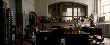 Movie still from “Juliet, Naked” (2018), directed by Jesse Peretz – A room with a table and chairs and a large window; Wide shot, High angle