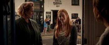 Movie still from “Juliet, Naked” (2018), directed by Jesse Peretz – A woman standing next to another woman on a street; Medium shot, Over the shoulder angle