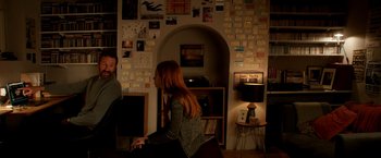 Movie still from “Juliet, Naked” (2018), directed by Jesse Peretz – A woman is playing the piano in a living room; Wide shot, High angle