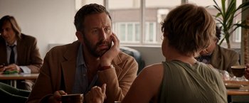 Movie still from “Juliet, Naked” (2018), directed by Jesse Peretz – A man and a woman sitting at a table talking to each other; Close Up shot, Over the shoulder angle
