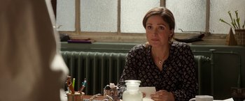 Movie still from “Juliet, Naked” (2018), directed by Jesse Peretz – A woman sitting at a table in front of a window; Close Up shot, Over the shoulder angle