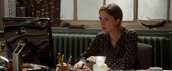 Movie still from “Juliet, Naked” (2018), directed by Jesse Peretz – A woman sitting at a table looking at a computer screen; Close Up shot, Over the shoulder angle