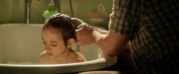 Movie still from “Juliet, Naked” (2018), directed by Jesse Peretz – A man washing a child's hair in a bath tub; Close Up shot, Over the shoulder angle