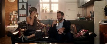 Movie still from “Juliet, Naked” (2018), directed by Jesse Peretz – A man and a woman sitting on a couch drinking wine; Medium shot, Over the shoulder angle
