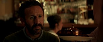 Movie still from “Juliet, Naked” (2018), directed by Jesse Peretz – A man with a beard is holding a tray of food; Close Up shot, Over the shoulder angle