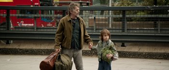 Movie still from “Juliet, Naked” (2018), directed by Jesse Peretz – A man and a boy holding hands while walking down a street; Medium shot, Over the shoulder angle