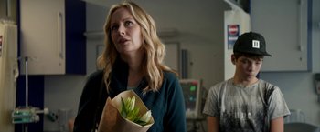 Movie still from “Juliet, Naked” (2018), directed by Jesse Peretz – A woman holding a paper bag with a plant in it; Medium shot, Over the shoulder angle