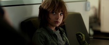Movie still from “Juliet, Naked” (2018), directed by Jesse Peretz – A young boy sitting in a chair looking at the camera; Close Up shot, High angle