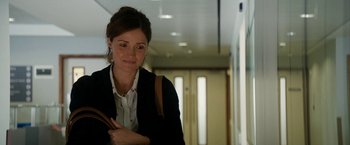 Movie still from “Juliet, Naked” (2018), directed by Jesse Peretz – A woman holding a purse while standing in a hallway; Medium shot, Over the shoulder angle