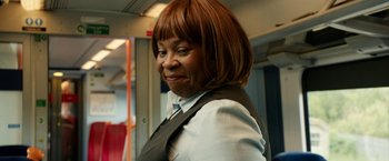 Movie still from “Juliet, Naked” (2018), directed by Jesse Peretz – A woman in a white shirt and a brown jacket; Medium shot, Over the shoulder angle