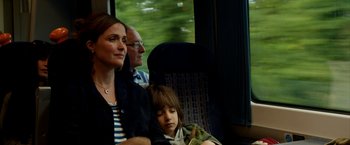 Movie still from “Juliet, Naked” (2018), directed by Jesse Peretz – A woman sitting next to a child on a train; Medium shot, Over the shoulder angle