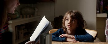 Movie still from “Juliet, Naked” (2018), directed by Jesse Peretz – A girl sitting at a table with a book in front of her; Close Up shot, Over the shoulder angle