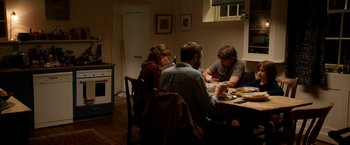 Movie still from “Juliet, Naked” (2018), directed by Jesse Peretz – A group of people sitting around a table eating food; Medium shot, High angle