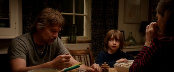 Movie still from “Juliet, Naked” (2018), directed by Jesse Peretz – A man and a boy sitting at a dinner table; Medium shot, Over the shoulder angle