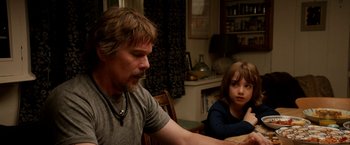 Movie still from “Juliet, Naked” (2018), directed by Jesse Peretz – A man sitting at a table with a child; Medium shot, Over the shoulder angle