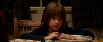 Movie still from “Juliet, Naked” (2018), directed by Jesse Peretz – A young child sitting at a table with a plate of food; Close Up shot, High angle