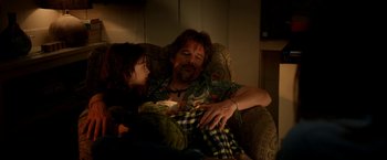 Movie still from “Juliet, Naked” (2018), directed by Jesse Peretz – A man sitting on a chair next to a little girl; Medium shot, Low angle