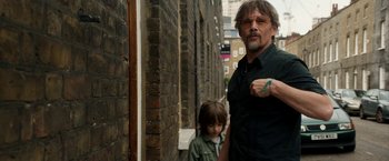 Movie still from “Juliet, Naked” (2018), directed by Jesse Peretz – A man standing next to a little girl in the street; Medium shot, Over the shoulder angle
