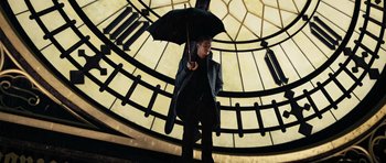 Movie still from “Jumper” (2008), directed by Doug Liman – A man holding an umbrella while standing in front of a building; Wide shot, Low angle