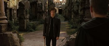 Movie still from “Jumper” (2008), directed by Doug Liman – A young man holding a stick in an abandoned building; Medium shot, Over the shoulder angle