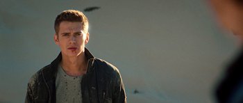 Movie still from “Jumper” (2008), directed by Doug Liman – A man in a leather jacket standing in front of a hill; Close Up shot, Low angle