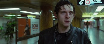 Movie still from “Jumper” (2008), directed by Doug Liman – A man in a leather jacket standing next to a wall; Close Up shot, Low angle